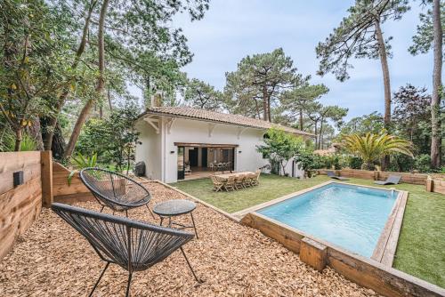 une cour arrière avec une piscine et une maison dans l'établissement Mon paradis, à La Teste-de-Buch
