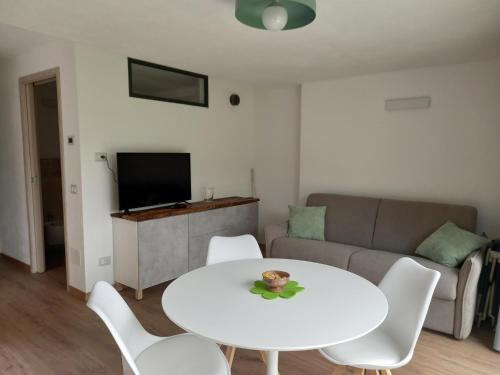 a living room with a white table and white chairs at Casa Borna da Ghiasa in Emarese