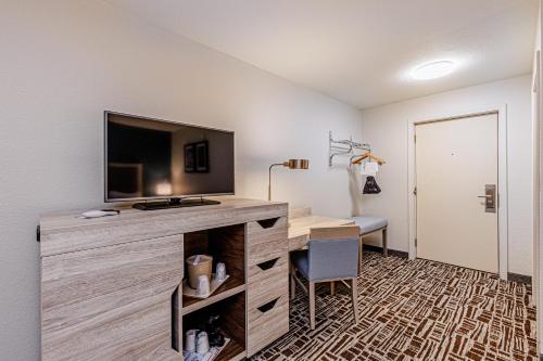 a room with a desk with a flat screen tv at Rivers Edge Motel in Cherokee