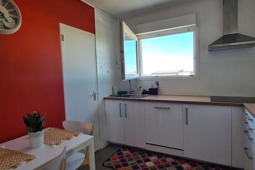 une cuisine avec des armoires blanches, un évier et une fenêtre dans l'établissement Chambre avec balcon RER A 20mn de Paris ou Disneyland, à Noisy-le-Grand