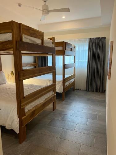a bedroom with two bunk beds in a room at Beachfront Jungle Luxury! 3BD Penthouse Uvita in Uvita