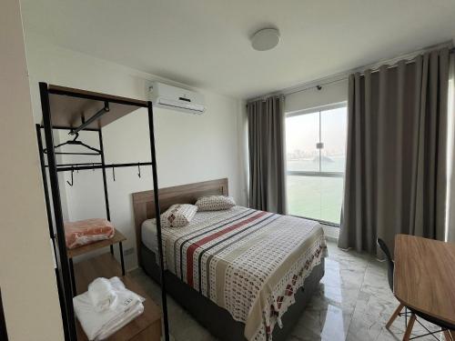 a bedroom with a bed and a window at Apartamento Paraíso da Ilha Porchat ! *Novíssimo!* in São Vicente