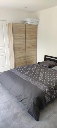 - un lit dans une chambre avec une couette noire dans l'établissement Chez Lucho et carole, à La Bastidonne