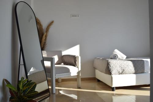 a mirror in a living room next to a chair at The Olive's Whisper in Skalánion