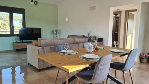 a living room with a wooden table and a couch at The Olive's Whisper in Skalánion