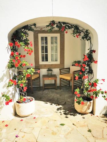 an archway with flowers in pots on a patio at Castle House and Beach in Sines