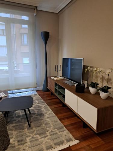 a living room with a flat screen tv on a table at M&P Nuevo in Bilbao