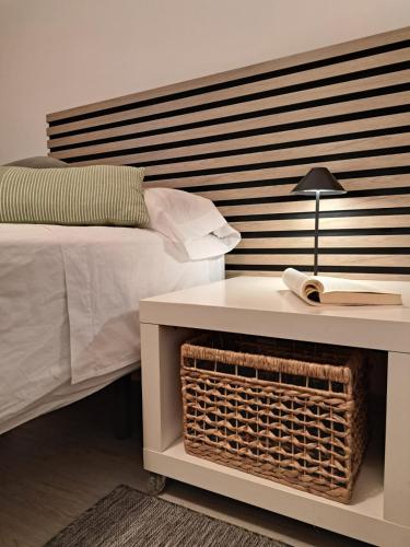 a bedroom with a bed and a table with a lamp at M&P Nuevo in Bilbao