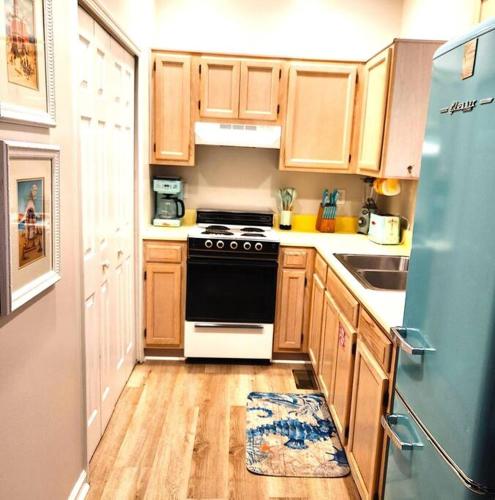 a kitchen with wooden cabinets and a black and white stove at The Floridian, Old Florida Charm with Modern Comfort in St. George Island