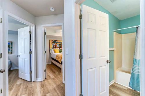 a room with a bedroom with a bed and two doors at The Floridian, Old Florida Charm with Modern Comfort in St. George Island