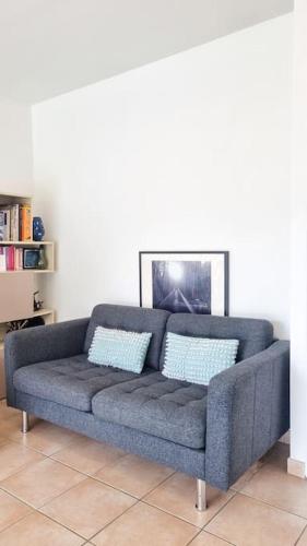 - un canapé dans le salon avec des oreillers bleus dans l'établissement Apartment in Annecy-le-Vieux near lake Albigny beach, à Annecy