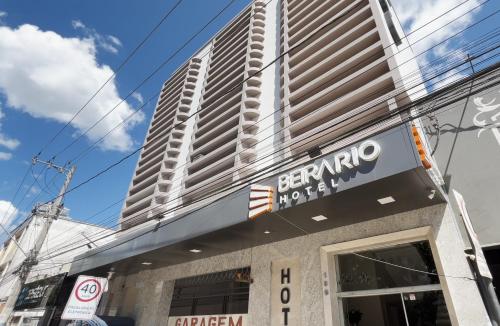 a sign on the front of a building with a tall building at Hotel Beira Rio in Teófilo Otoni
