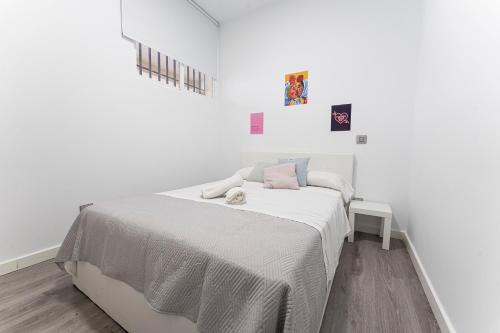 una camera bianca con un letto su una parete bianca di Hogar en Calle Lavapiés a Madrid