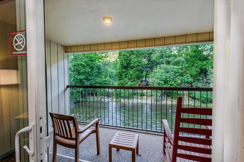 a screened in porch with two chairs and a window at Rivers Edge Motel in Cherokee