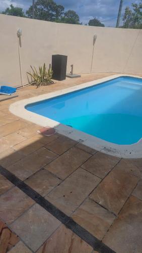 a large blue swimming pool next to a white wall at Villa Essarbel in Pereybere