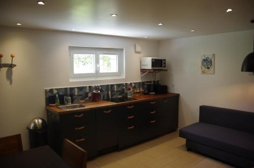 d'une cuisine avec un comptoir, un évier et une fenêtre. dans l'établissement Oriana & Philippe au pied du métro 4, à Bagneux