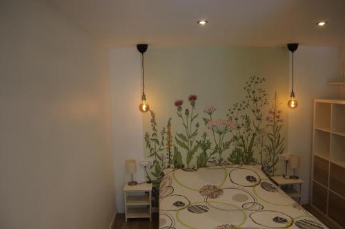 - une chambre avec un lit orné de fleurs sur le mur dans l'établissement Oriana & Philippe au pied du métro 4, à Bagneux