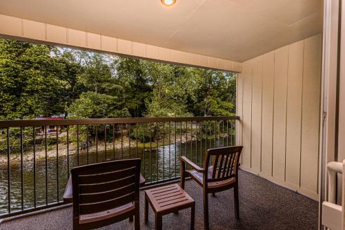 two chairs on a balcony with a view at Rivers Edge Motel in Cherokee