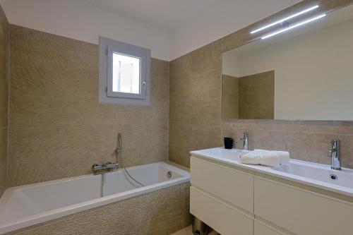 a bathroom with a tub and a sink and a bath tubermott at Villa avec piscine in Plan-de-la-Tour