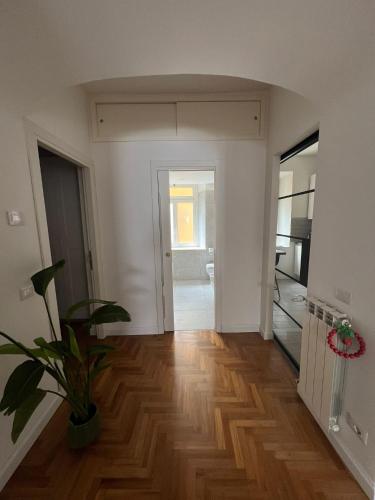 an empty living room with a potted plant on a wooden floor at Luxury Apartment Via Veneto in Rome