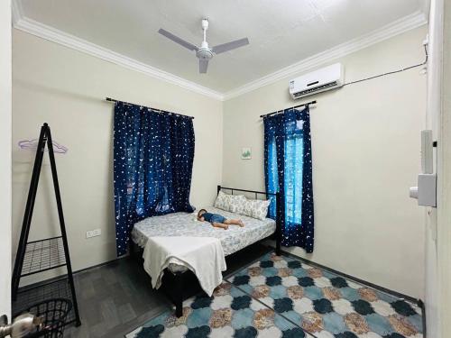 a bedroom with a bed with blue drapes at Homestay D' Chemumaq Arau in Arau