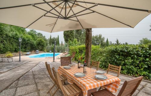 una mesa con sombrilla junto a una piscina en Il Loggiato, en Monte San Savino