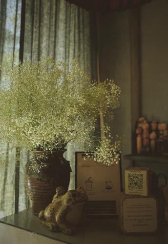 a vase with flowers in it on a table at La Maison Des Délices in Da Nang