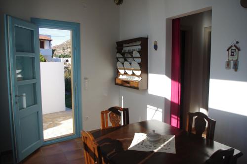 a dining room with a wooden table and a door at Villa Patmos Netia in Patmos