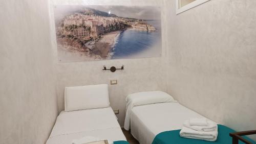 a room with two beds and a picture of a city at Residenza Casale San Francesco free parking in Tropea