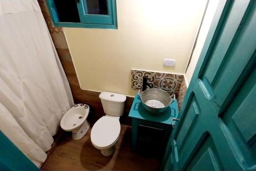 a small bathroom with a toilet and a green door at La casita Espiritual in San Rafael