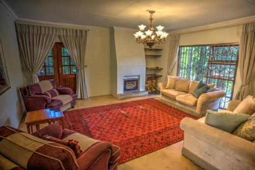 a living room with couches and a fireplace at Pavetta Country House in Magoebaskloof