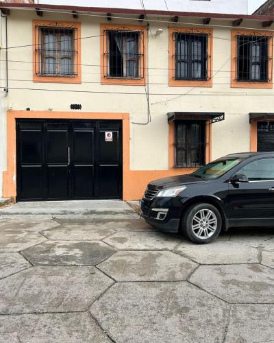 a black car parked in front of a building at Casa De Liz in San Cristóbal de Las Casas