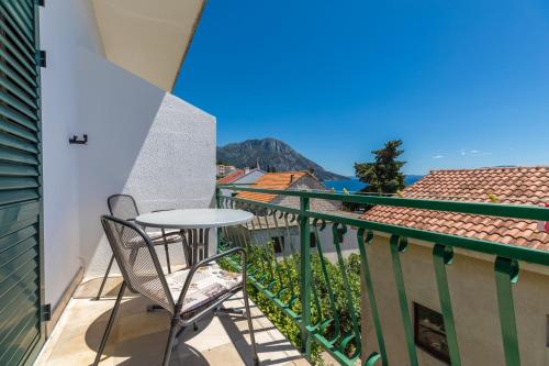 a balcony with a table and chairs on a building at Apartments by the sea Brist, Makarska - 22463 in Podaca