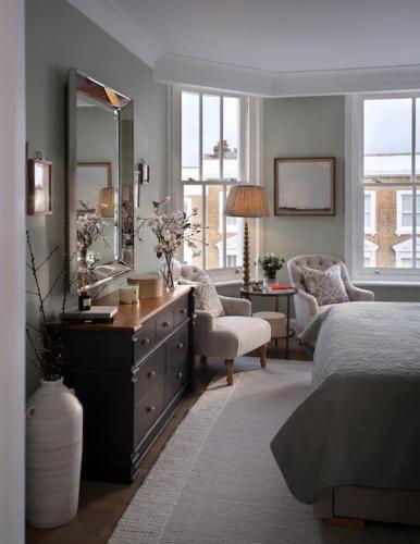 a bedroom with a bed and a dresser with a mirror at 3 Bed Corner House Portobello Rd in London