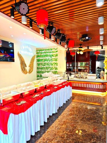 a restaurant with a long table with red and white tables at Moalboal Seaside Resort in Moalboal