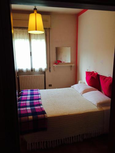 a bedroom with two beds with red and purple pillows at Locanda Irene in Monte San Pietro
