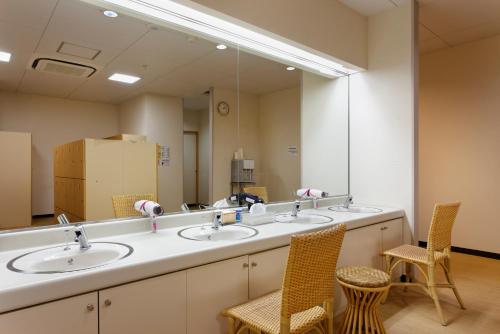 a bathroom with three sinks and a large mirror at Hotel Frontier Iwaki in Iwaki