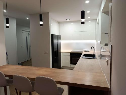 a kitchen with a wooden table and a black refrigerator at Seaside holiday house Podobuce, Peljesac - 23460 in Orebić