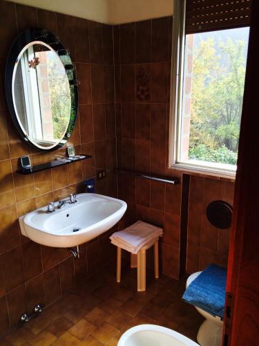 a bathroom with a sink and a mirror and a toilet at Locanda Irene in Monte San Pietro