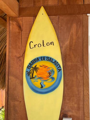 a yellow surfboard with a sign on it at Cabaña Croton Punto Surf Barra la Saladita in La Salada