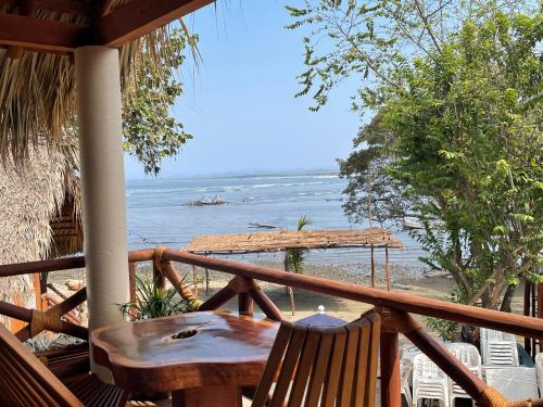 a porch with a table and a view of the ocean at Cabaña Croton Punto Surf Barra la Saladita in La Salada