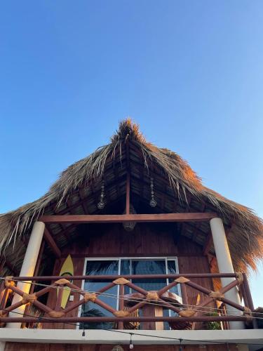 a building with a straw roof with a window at Cabaña Croton Punto Surf Barra la Saladita in La Salada