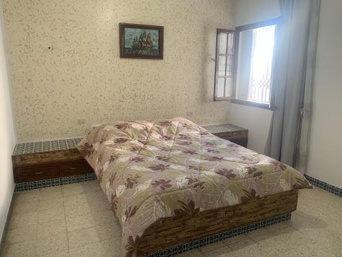 a bedroom with a bed and a window at Villa Soliman Plage in Soliman