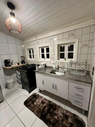 een keuken met een spoelbak en een fornuis bij Residencial Casuarina Monte Verde in Camanducaia