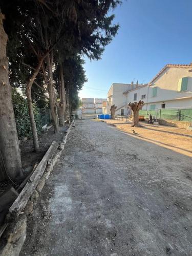 une route vide bordée d'arbres dans l'établissement Haut de Villa, Jardin, Piscine !, à Fos-sur-Mer