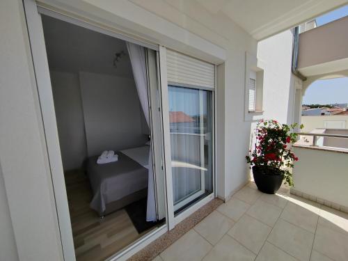 Balcón con habitación con cama y ventana en Mila Apartments Zadar, en Zadar