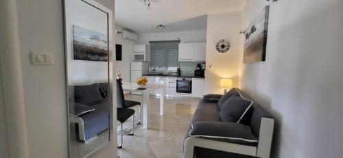 Una sala de estar con un sofá y sillas y una cocina. en Mila Apartments Zadar, en Zadar