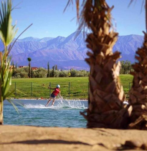 a person is water skiing in a lake at les jardins d'atlas waky palm golf in Marrakech