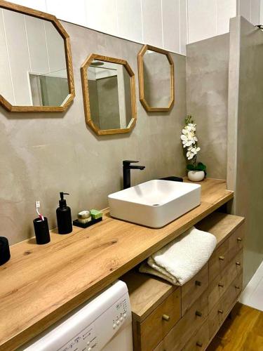 La salle de bains est pourvue d'un lavabo et de miroirs sur un comptoir. dans l'établissement appartement T2, à Bordeaux