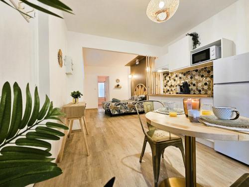 une cuisine et un salon avec une table et des chaises dans l'établissement Tout confort ! Balnéo, Sauna, Cinéma, Climatisation, Parking, WiFi, à Carcassonne